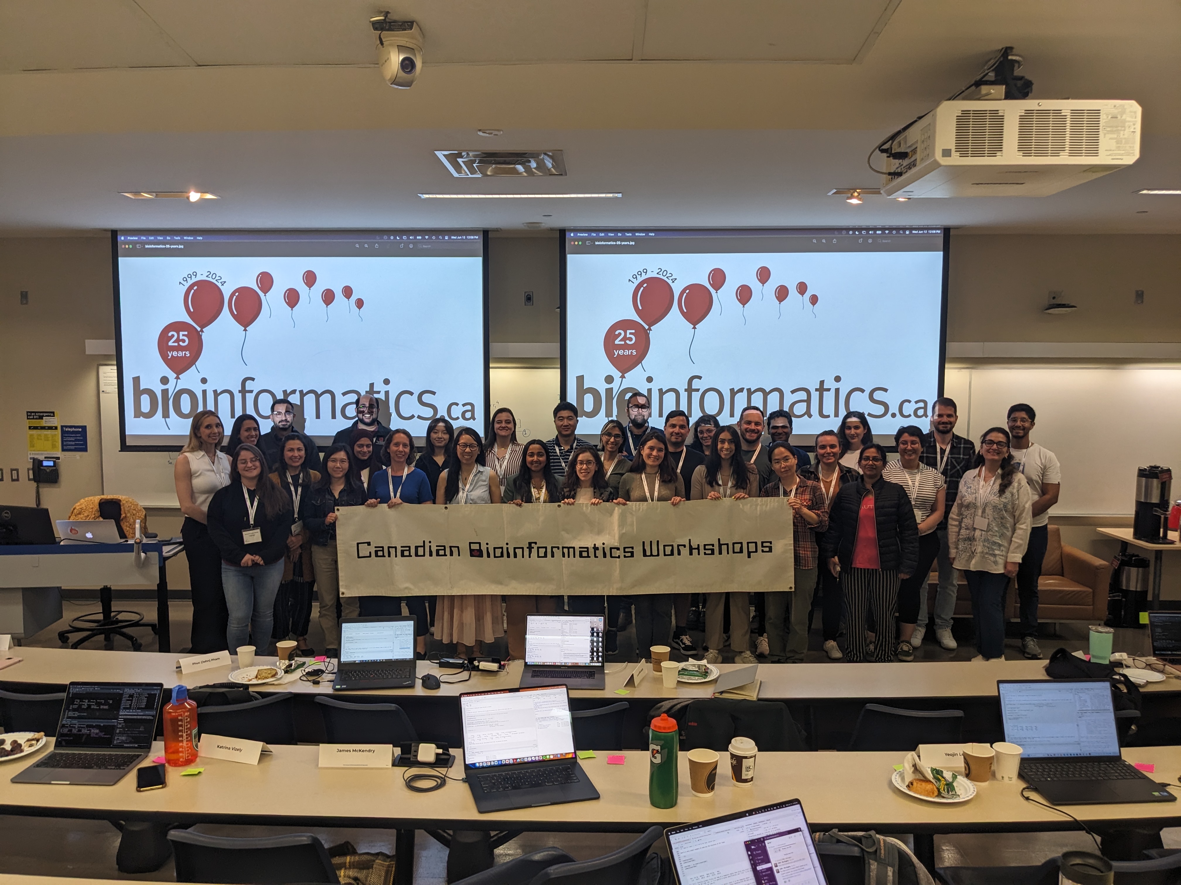 The photo shows the attendees of 2024’s Introduction to R workshop standing witha “Canadian Bioinformatics Workshops” banner.